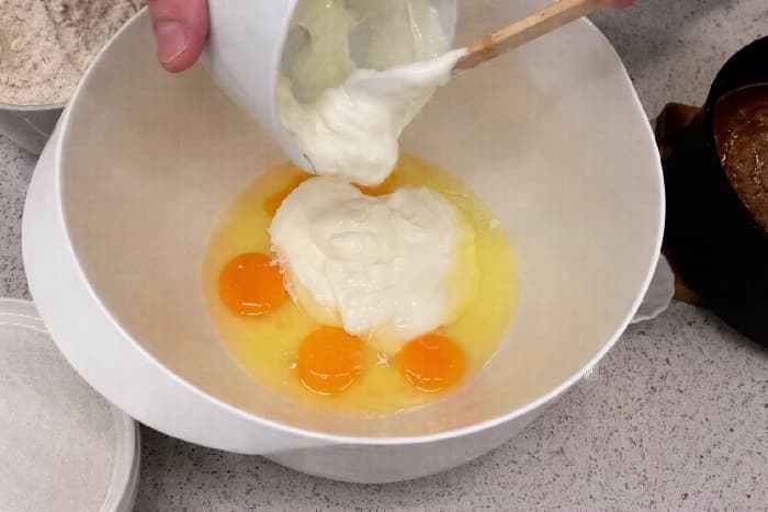 Egg og rømme blandes sammen i en bolle før tilberedning av sjokoladekaken.