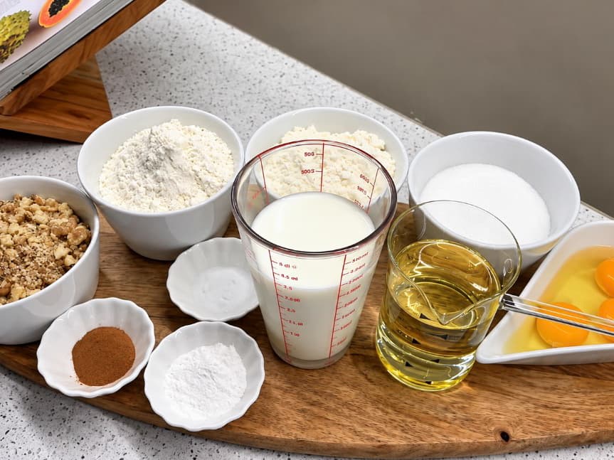 Ingrediensene til gresk Karidopita med valnøtter, mel, sukker, melk, olje, egg og kanel.