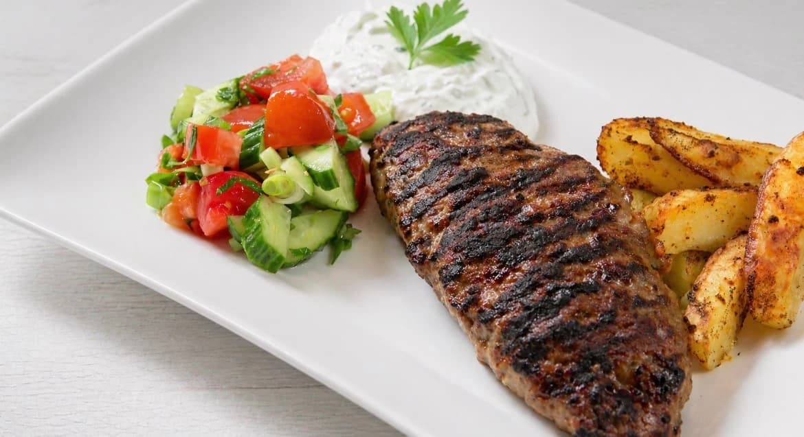 Fylt kjøttdeig med fetaost servert med ovnsbakte poteter, frisk salat og tzatziki.