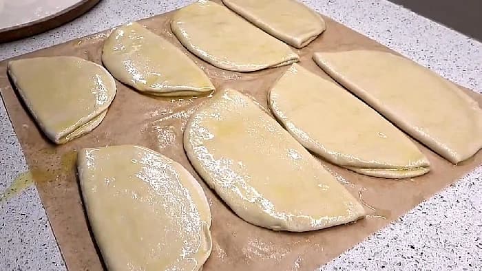 Deigleiver brettes sammen og smøres med smør og olje for å bli myke og elastiske før de strekkes ut.