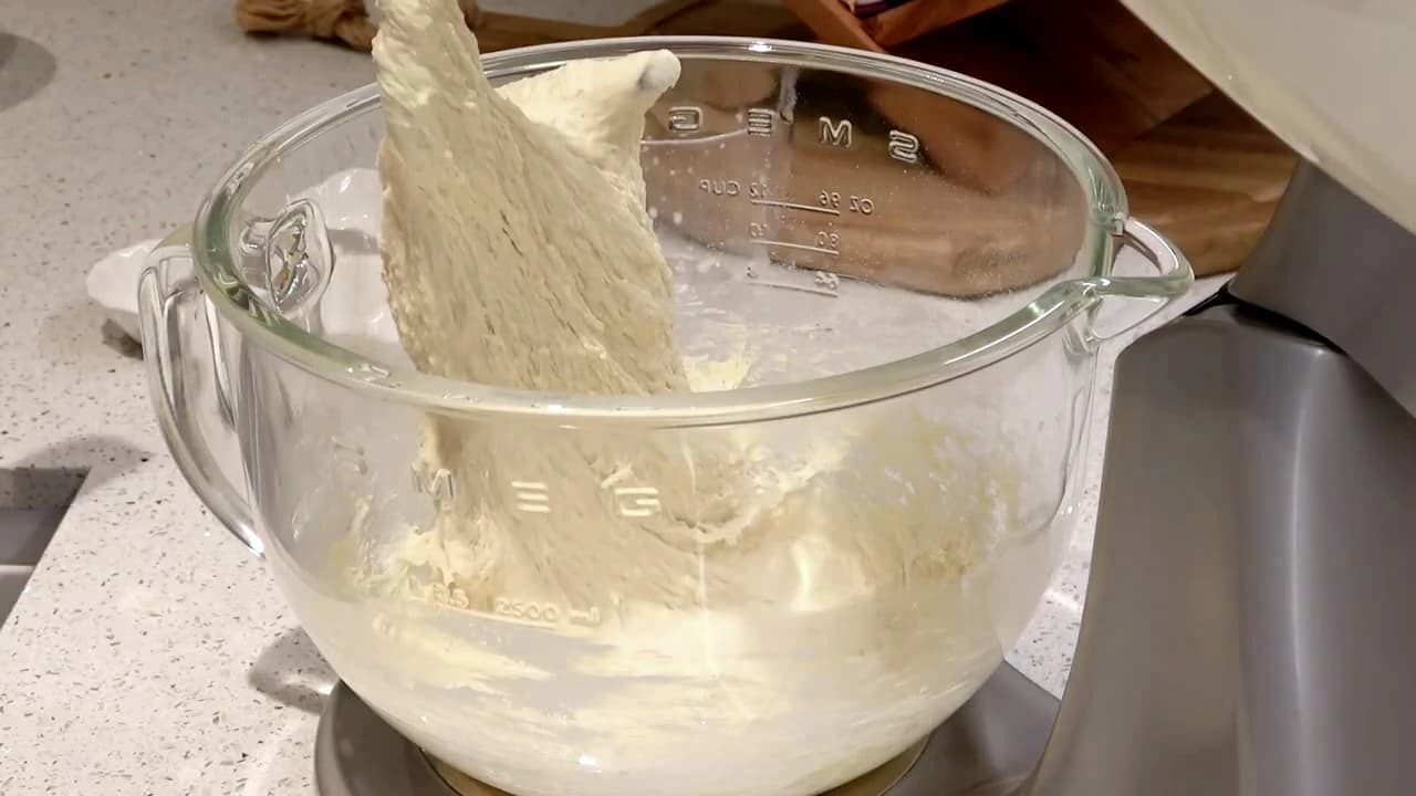Ferdigeltet deig til hjemmelagde hamburgerbrød løftes opp fra bakebollen.