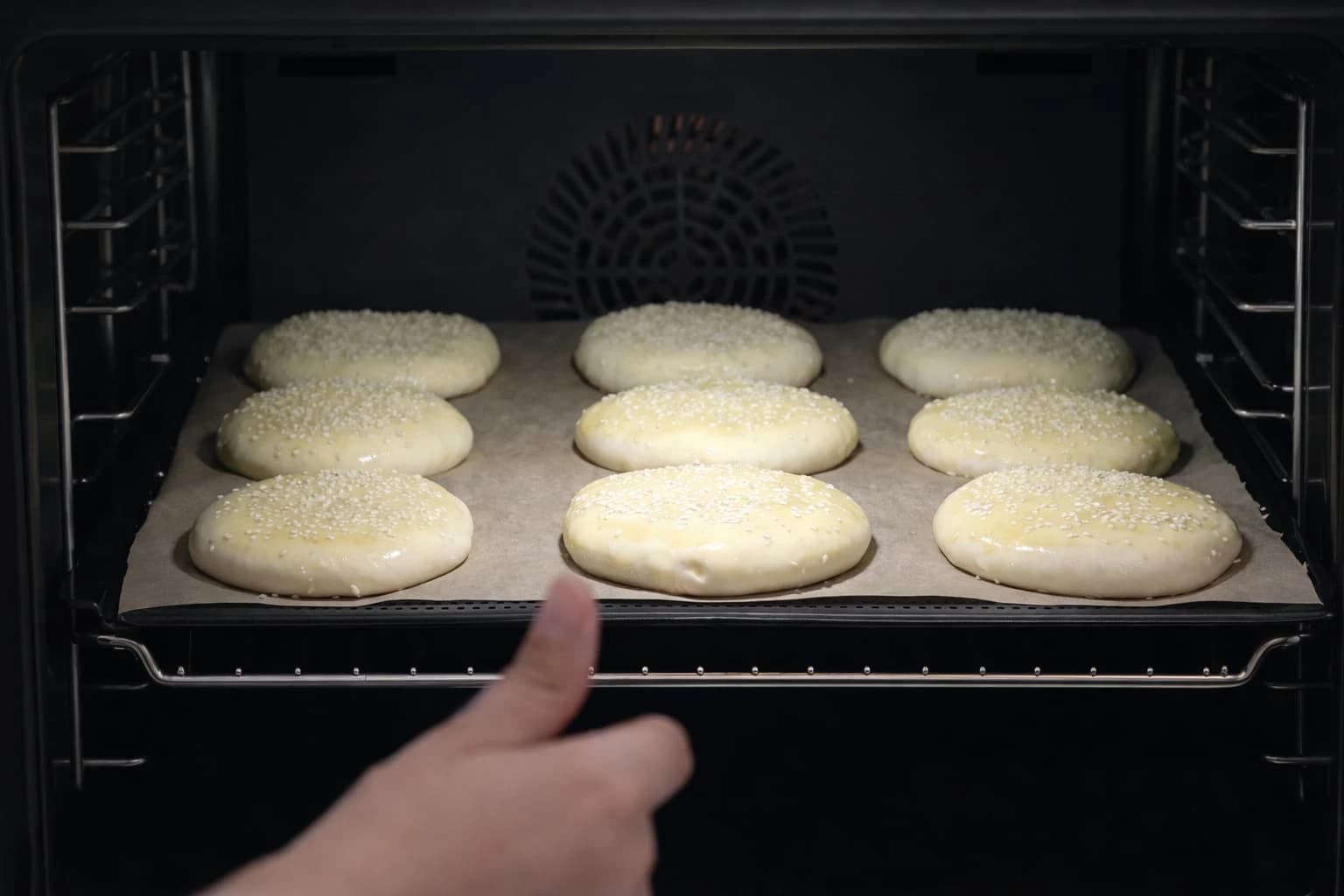 Hamburgerbrød med sesamfrø settes inn i ovnen for steking ved 220 grader.